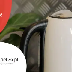 Biały czajnik z czarną rączką, na tle metalowej płyty i zielonych liści. Tekst: "Jak odkamienić czajnik? Sprawdzone domowe sposoby".