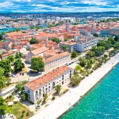 Zadar we wrześniu: słoneczna pogoda, turkusowe morze i urokliwe miasto z czerwonymi dachami. Idealne miejsce na wakacje.