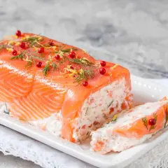 Une délicieuse terrine de saumon, garnie d'aneth, de baies roses et de zeste de citron, prête à être dégustée.