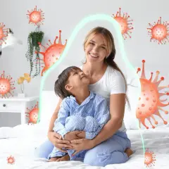 Matka tuli dziecko, które ma kaszel w nocy. Wokół nich unoszą się wirusy, ale chroni je zielona bariera.