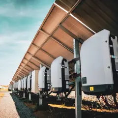 Rząd falowników pod panelami fotowoltaicznymi. Kluczowe dla instalacji, jak dobrać moc falownika, by działał optymalnie.