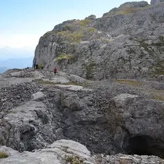 Senderismo en la vega de Liordes, un paisaje rocoso con un grupo de personas observando un abismo.