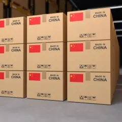 Paczki z Chin piętrzą się w magazynie, gotowe do wysyłki. Każde pudełko z chińską flagą i napisem "Made in China" czeka na swoją podróż.