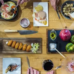Una mesa llena de delicias para una ruta tapas: croquetas, montadito, huevo con jamón, patatas y calamares. ¡Buen provecho!