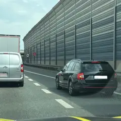 Korek na autostradzie, samochody i ciężarówki stoją w rzędzie. Kierowcy powinni pamiętać o jazda na suwak przepisy, by płynnie włączyć się do ruchu.