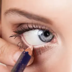 Aplicando delineador en la linea de agua del ojo, creando un look intenso.