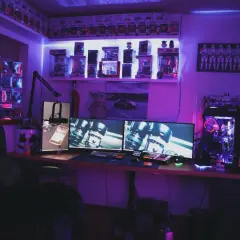 Zestaw komputerowy z podświetleniem RGB, idealny do gier z wykorzystaniem **DirectX**. Na półkach figurki Funko Pop i gadżety Star Wars.