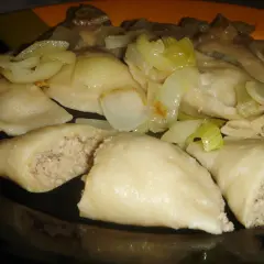 Pyszne pierogi z mięsem i kapustą, polane podsmażoną cebulką, kuszą swoim domowym wyglądem.