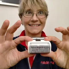 Donna sorridente mostra un timbro con i dati di una psicologa. Utile per sapere cosa scrivere su un timbro psicologo.