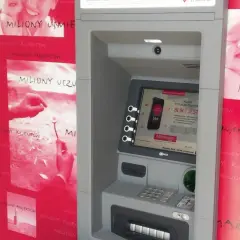 Bankomat Millennium z hasłem "miliony uśmiechów". Obok reklamy z uśmiechniętymi dziećmi i hasłem "miliony uczuć".