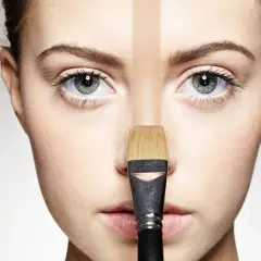 Un visage divisé par une ligne de fond de teint trop foncé, appliqué au pinceau.