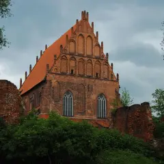 Gotycka ceglana bazylika w **starym mieście Elbląg** z charakterystycznym szczytem i dachówką.