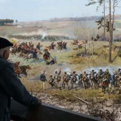 Widok na bitwę z obrazu **Panorama Racławicka**, namalowanego przez Jana Styke i Wojciecha Kossaka.