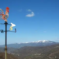 Gallo segnavento su sfondo di montagne innevate in Valmarecchia. Scopri cosa vedere in questa splendida cornice naturale.