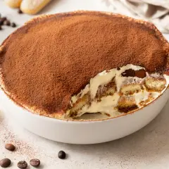 Un invitante tiramisù, una soffice mousse al cioccolato cosparsa di cacao, con savoiardi inzuppati e crema.