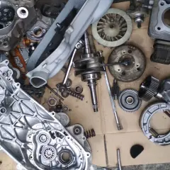 Parti di motore di scooter smontate, pronte per un progetto di garage officina fai da te.