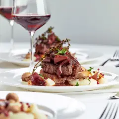 Eleganckie danie z wołowiny z puree, grzybami i cebulą, podane z czerwonym winem. Idealne na specjalne okazje, zastanawiasz się, ile za osobę na wesele?