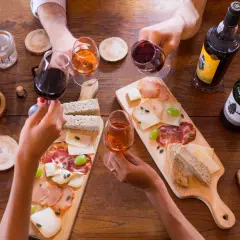 Hände reichen sich Gläser mit Portwein, dazu gibt es Brot, Käse und Aufschnitt. Was ist Portwein? Ein süßer, aufgespriteter Wein aus Portugal.