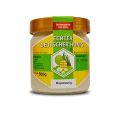 Glas mit cremigem Rapshonig, "Echter Deutscher Honig" steht drauf. Dieser Honig ist gesund und lecker.