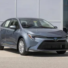 Grigio Toyota Corolla, un'auto a metano ecologica, parcheggiata davanti a un edificio moderno.