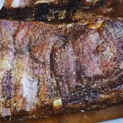 Pyszne żeberka pieczone w piekarniku w naczyniu, przyprawione i rumiane.