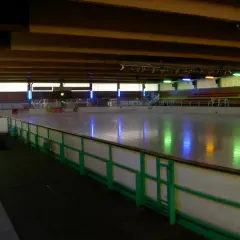 Leere Eisfläche in der Eissporthalle Bergisch Gladbach, beleuchtet von bunten Lichtern.