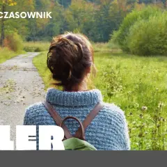 Kobieta w jesiennym swetrze i plecakiem idzie ścieżką w lesie. To **aller odmiana** natury.