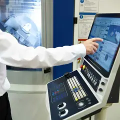 Ustawiacz wtryskarek obsługuje panel sterowania maszyny, dostosowując parametry produkcji.