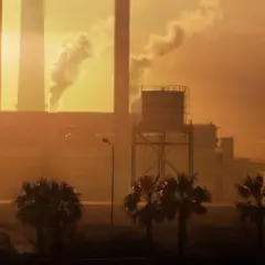Paisaje industrial con chimeneas humeantes al atardecer. Ojalá se pudiera aplicar **limpieza con ozono** para purificar el aire.