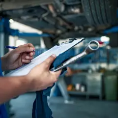 Mechanik spisuje listę usterek. Brak przeglądu, auto na podnośniku.