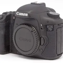 Czarny aparat Canon EOS 7D. Zastanawiasz się dslr co to? To właśnie taki aparat, z wymiennym obiektywem i lustrem.