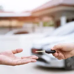 Une main tend une clé de voiture à une autre main ouverte. Idéal pour une assurance conducteur occasionnel.