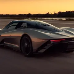 Szary McLaren Speedtail pędzi po pustej drodze o zachodzie słońca.
