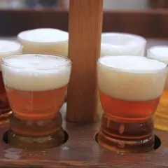 Degustacja najlepszego czeskiego piwa. Sześć małych kufelek z pianką na drewnianej desce.