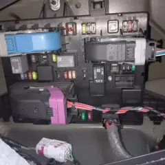 Panel bezpieczników w Opel Astra J, z widocznymi bezpiecznikami i przekaźnikami.