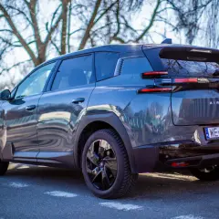 Ciemnoszary Citroën C5 Aircross Hybrid zaparkowany pod drzewami. Widok z tyłu, z tablicą rejestracyjną WE 9JL73.