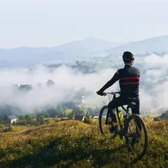 Rowerzysta podziwia mglisty krajobraz Dolnego Śląska. Widok na dolinę i góry.