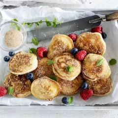 Små, gyllene krabbelurer, strösslade med socker och kanel, serveras med färska bär. Ett enkelt krabbelurer recept för fika.