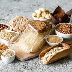 Różnorodne produkty spożywcze, w tym ryż, makaron, pieczywo, kasza, płatki owsiane i nasiona.