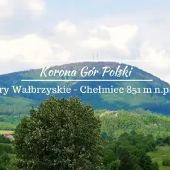 Widok na górzysty krajobraz z dominującym szczytem Chełmiec. Na pierwszym planie bujna zieleń drzew, w oddali łagodne zbocza górskie pokryte lasem.