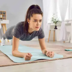 Donna in posizione di plank, parte di un allenamento metabolico casalingo. Sul tappetino, manubri blu.