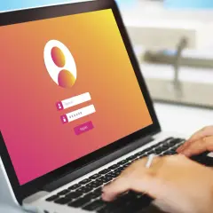 Laptop con pantalla de inicio de sesión. Se ve un campo para "Name ID" y otro para contraseña, con un botón "Register". La interfaz parece ser una firma digital en Google Chrome.
