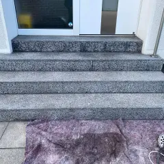 Schritt für Schritt wird die Marmortreppe gereinigt. Ein Schutzvlies liegt bereit, Werkzeug für die Reinigung ist zu sehen.