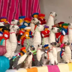 A collection of charming, handmade llama stuffed animals, showcasing creative stuffed animal storage ideas.