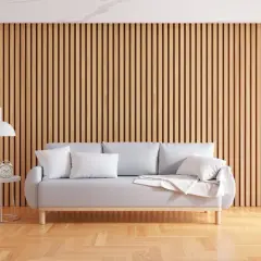 Sofa z poduszkami na tle drewnianej ściany z lameli.