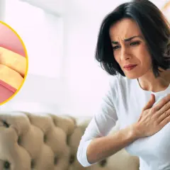 Kobieta trzymająca się za serce obok schematu zatkanego cholesterolem naczynia krwionośnego.