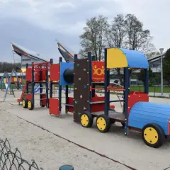 Kolorowy pociąg na placu zabaw w parku rozrywki Zawada. Dzieci mogą wspinać się, zjeżdżać i bawić się na tej interaktywnej konstrukcji.