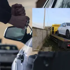 Złodziej próbuje włamać się do auta, które może należeć do najczęściej kradzionych aut. Na drugim planie biały samochód na lawecie.