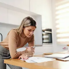 Kobieta analizuje dokumenty, być może planując, jak najlepiej zarządzać swoim dochodem nieopodatkowanym.