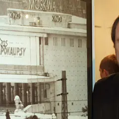 Chris Niedenthal obok plakatu "Czas Apokalipsy" z kinem Moskwa w tle.